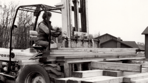 Woman moving lumber with large forklift at Crescent Construction Company, a woman owned business collective.