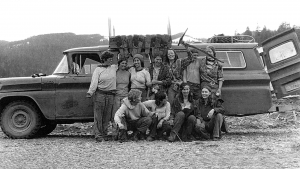 Several women from the all women tree planting co-op, Full Moon Rising pose in front of truck wearing workwear.